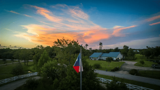 Texas flag over farm house