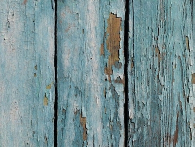 A close-up shot of weathered, blue-painted wooden boards.