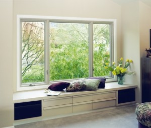 A large, bright window with a built-in window seat and drawers below.