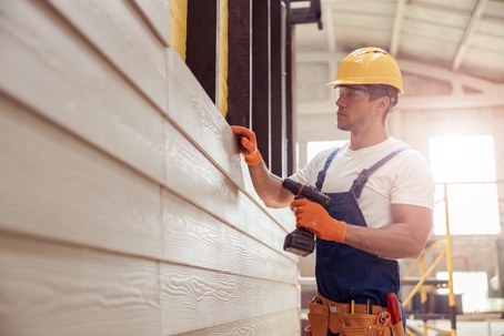 man checking siding material