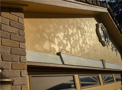 This close-up shows the stucco siding of a home, which has areas of discoloration.