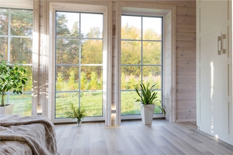 A bright, well-lit room features large pane windows with natural light and a view of the outdoors.