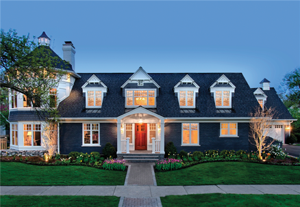 A large, dark blue house with many windows is centered in the frame.