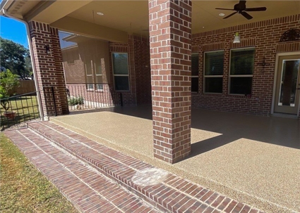 A patio with brick stairs leads to a covered area, supported by a brick pillar.