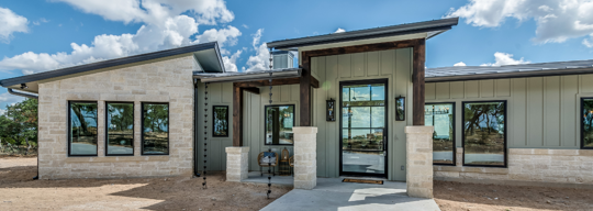 A modern home exterior with a stone base and light-green siding is featured.