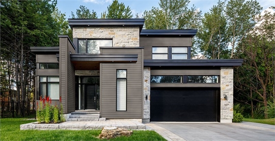 A two-story modern home with gray siding and stone accents.