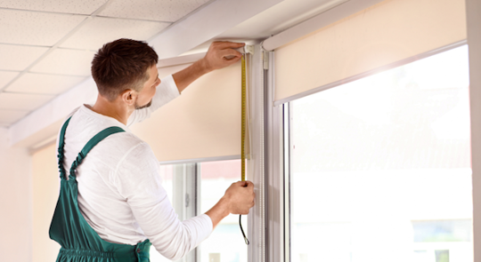man measuring a window blinds