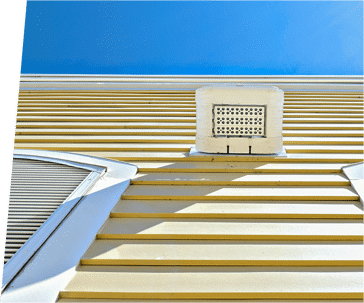 Close-up of yellow HardiePlank siding, with a white air vent and window.