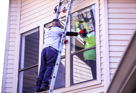 Two men are shown replacing a window.