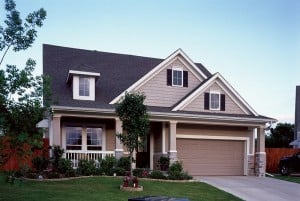 A tan home with two roof dormers.