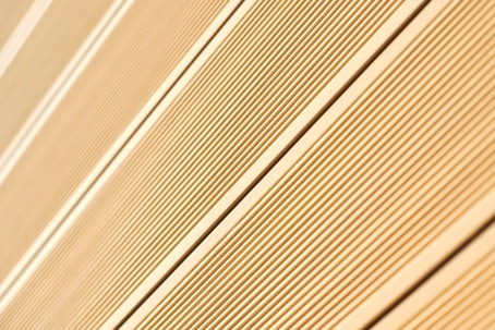 light brown textured wall shows parallel lines, possibly on a door or cabinet.