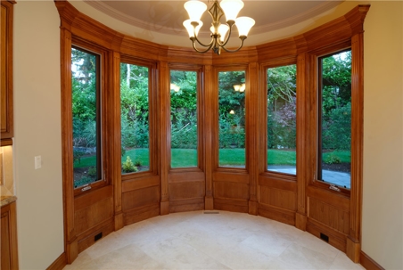 A five-section bay window with wood trim and a chandelier.
