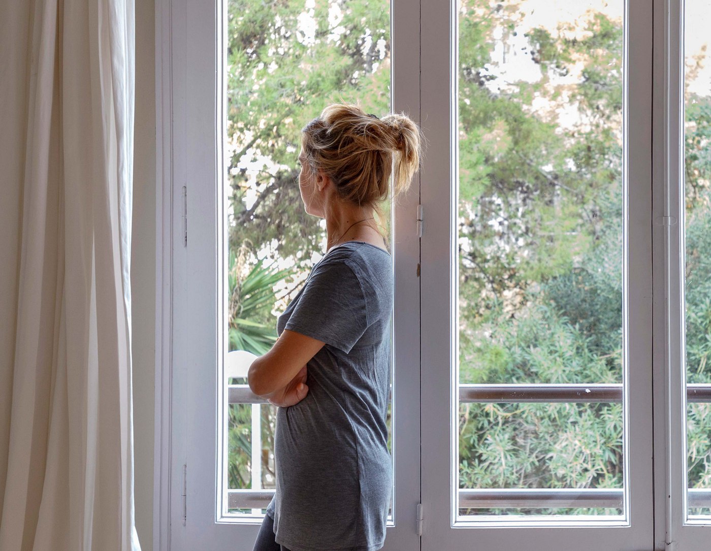 woman-at-home-looking-out-of-window-2021-11-18-02-28-13-utc