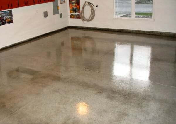 The inside of a garage with a plain concrete floor with a shiny acrylic coating.