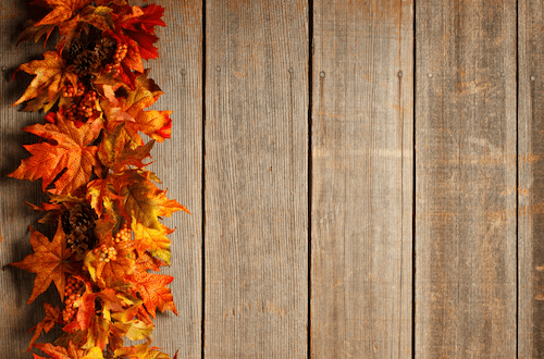 Fall foliage garland against a wooden background.