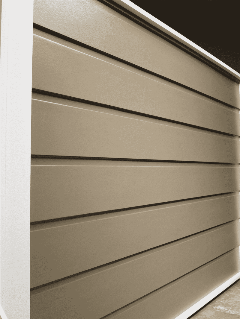 A wall of dutch smooth horizontal siding in a dark beige color.