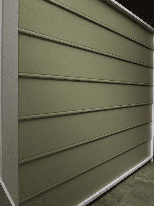 A siding sample in a warehouse of beaded seam siding that is army green.